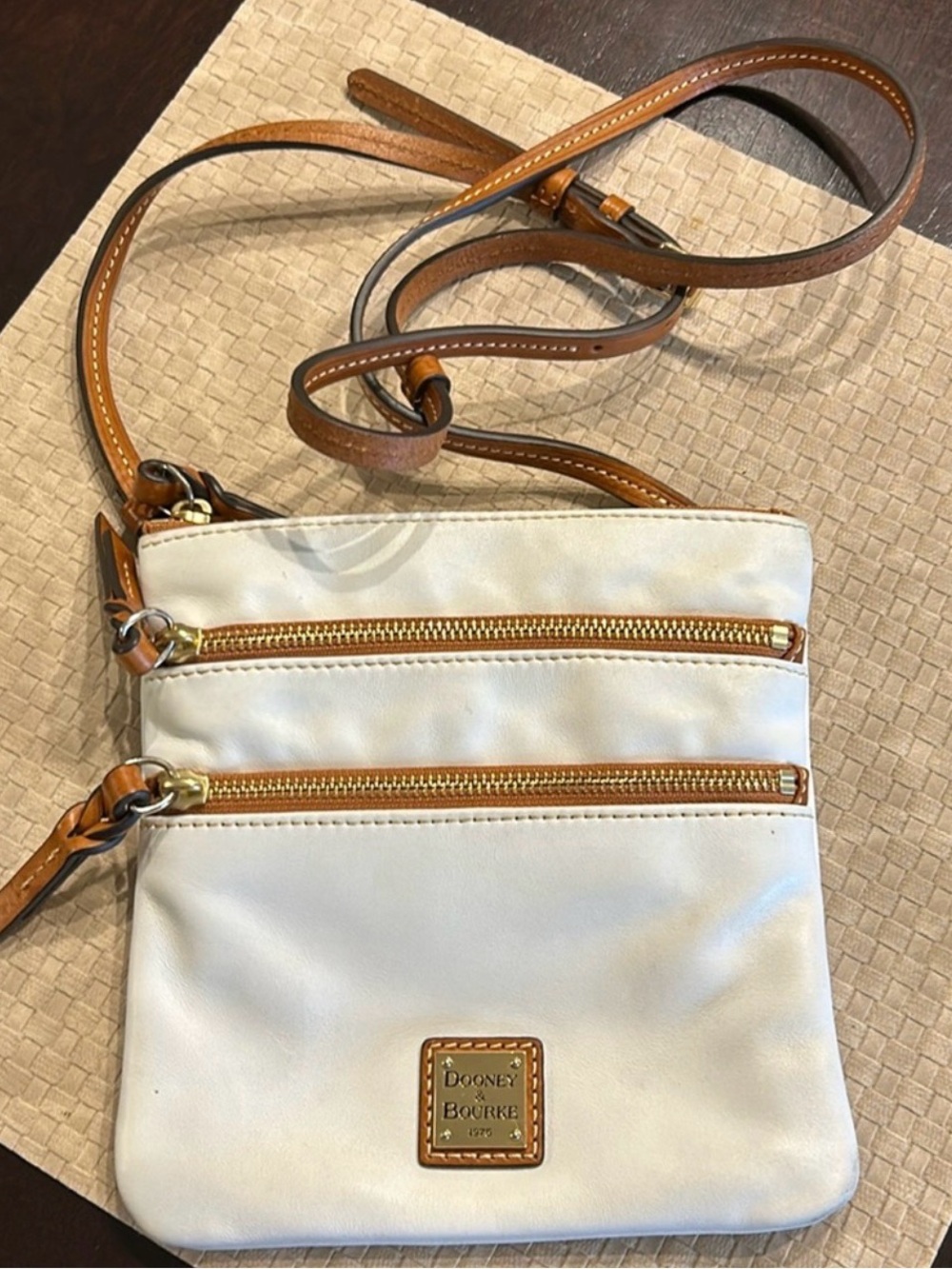 Dooney & Burke small white leather crossbody bag with adjustable strap.
